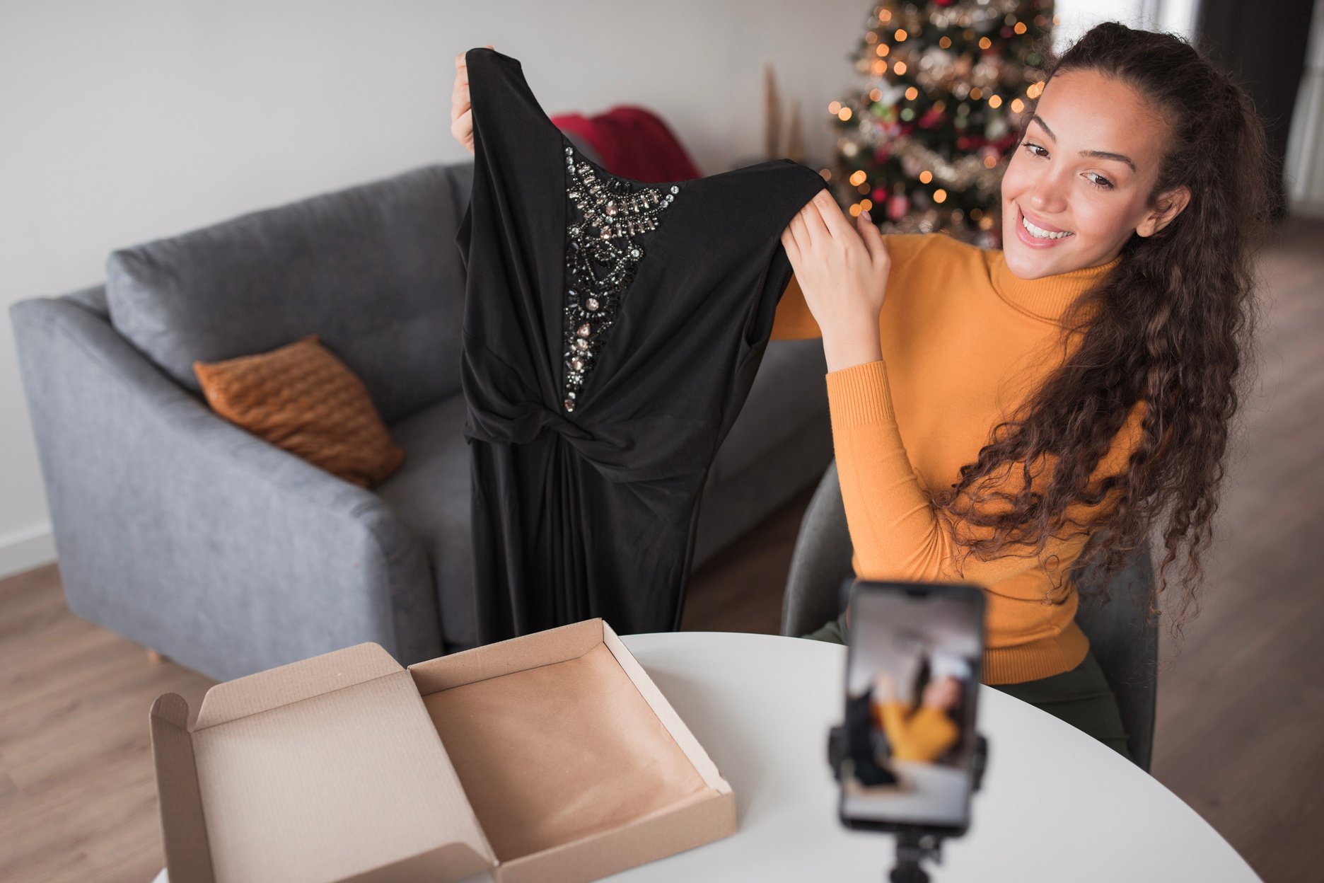 Happy influencer live-streaming e-commerce selling clothes at home